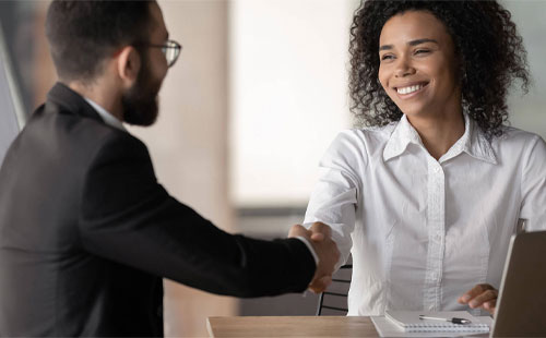 Businessman and Businesswoman shaking hands in office