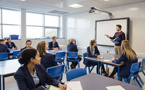 Male teacher is teaching a group of teenagers in a secondary school lesson